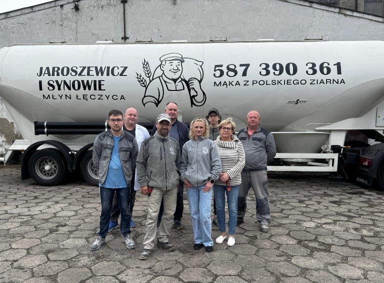 Zdjęcie zespołu młyna na tle cysterny z danymi kontaktowymi do zakupu hurtowego mąki